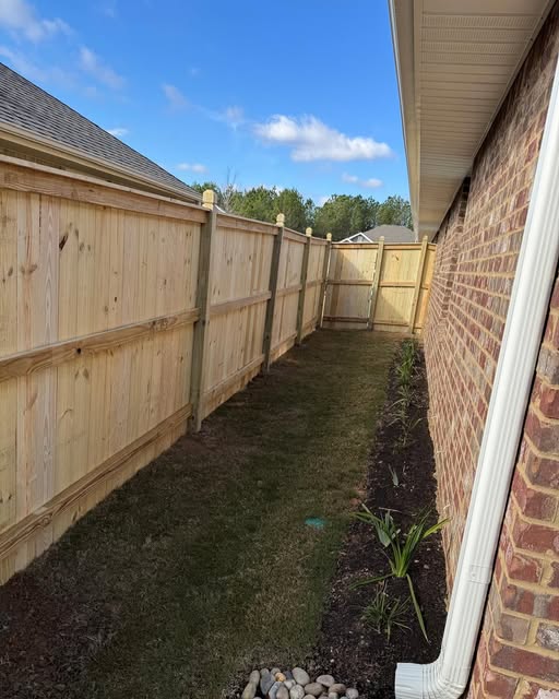 New wooden privacy fence beside a landscaped side yard