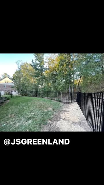 Finished black metal fence following a landscaped hillside